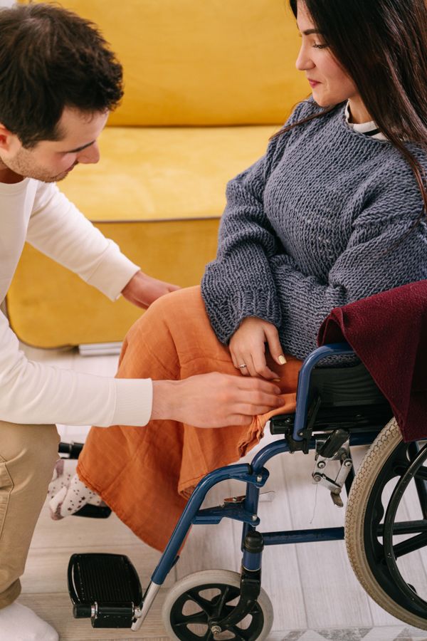 A support worker assisting a woman using a wheelchair indoors